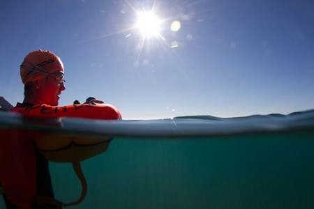 Swimmer resting on Orca swim buoy